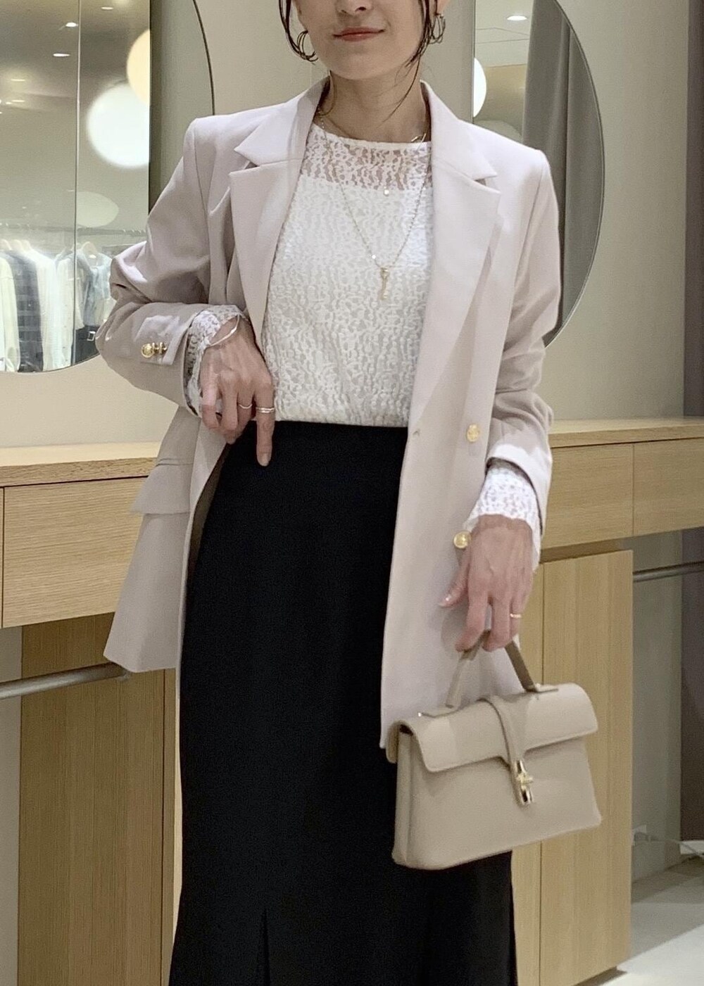 ブラック系のスカート、ホワイト系のTシャツ/カットソー、ベージュ系のテーラードジャケットを着用したレディースの冬コーディネートの7枚目の写真