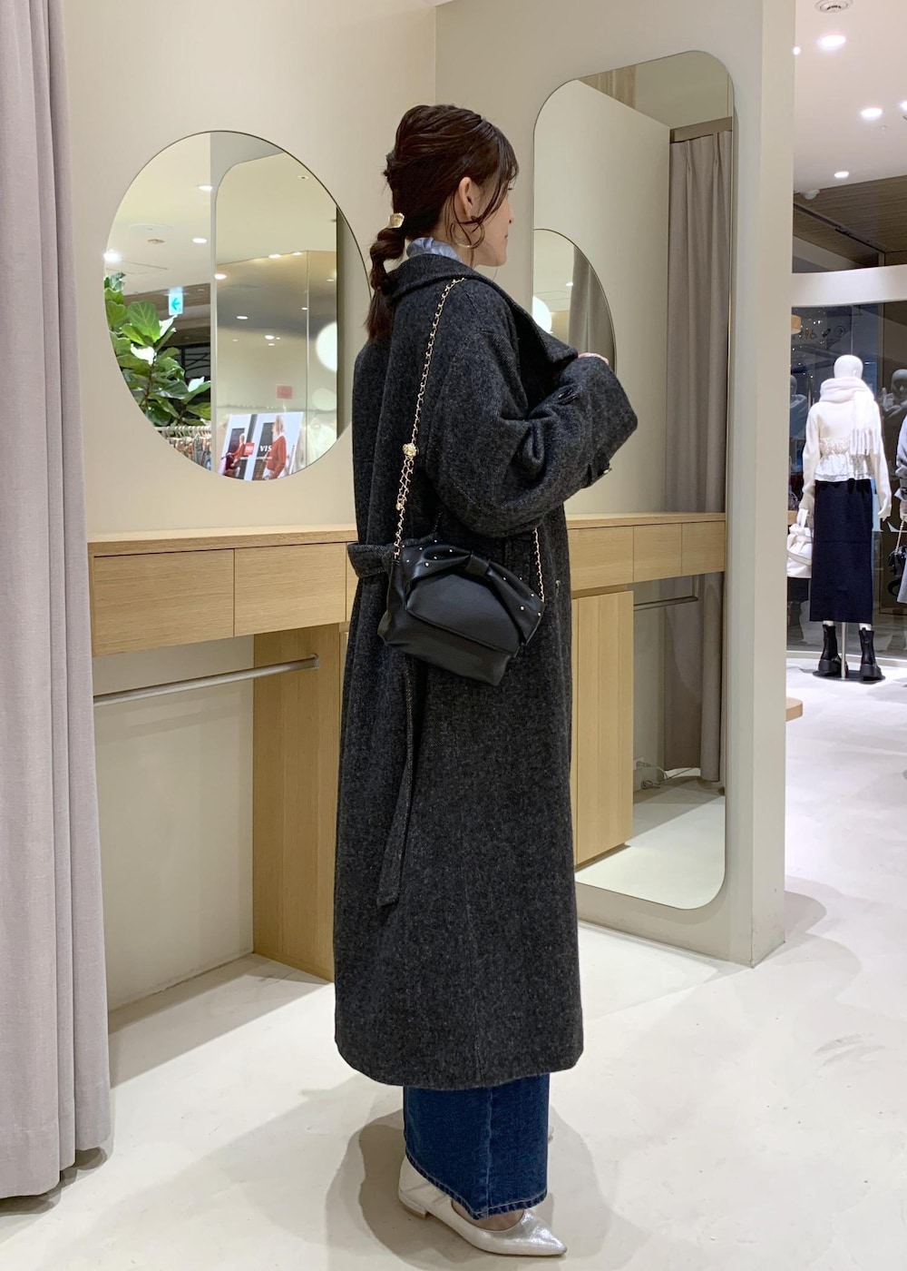 ブルー系のデニムパンツ、グレー系のその他アウター、ブラック系のショルダーバッグを着用したレディースの冬コーディネートの3枚目の写真