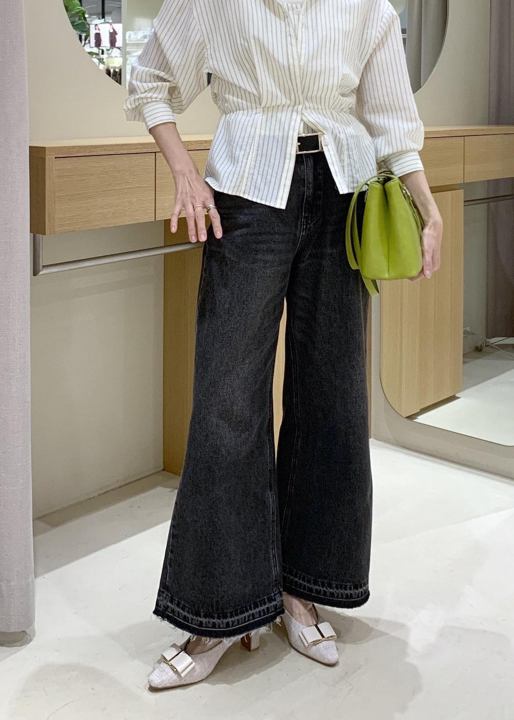 ホワイト系のキャミソール、ベージュ系のパンプス、ブラック系のデニムパンツを着用したレディースの春コーディネートの8枚目の写真