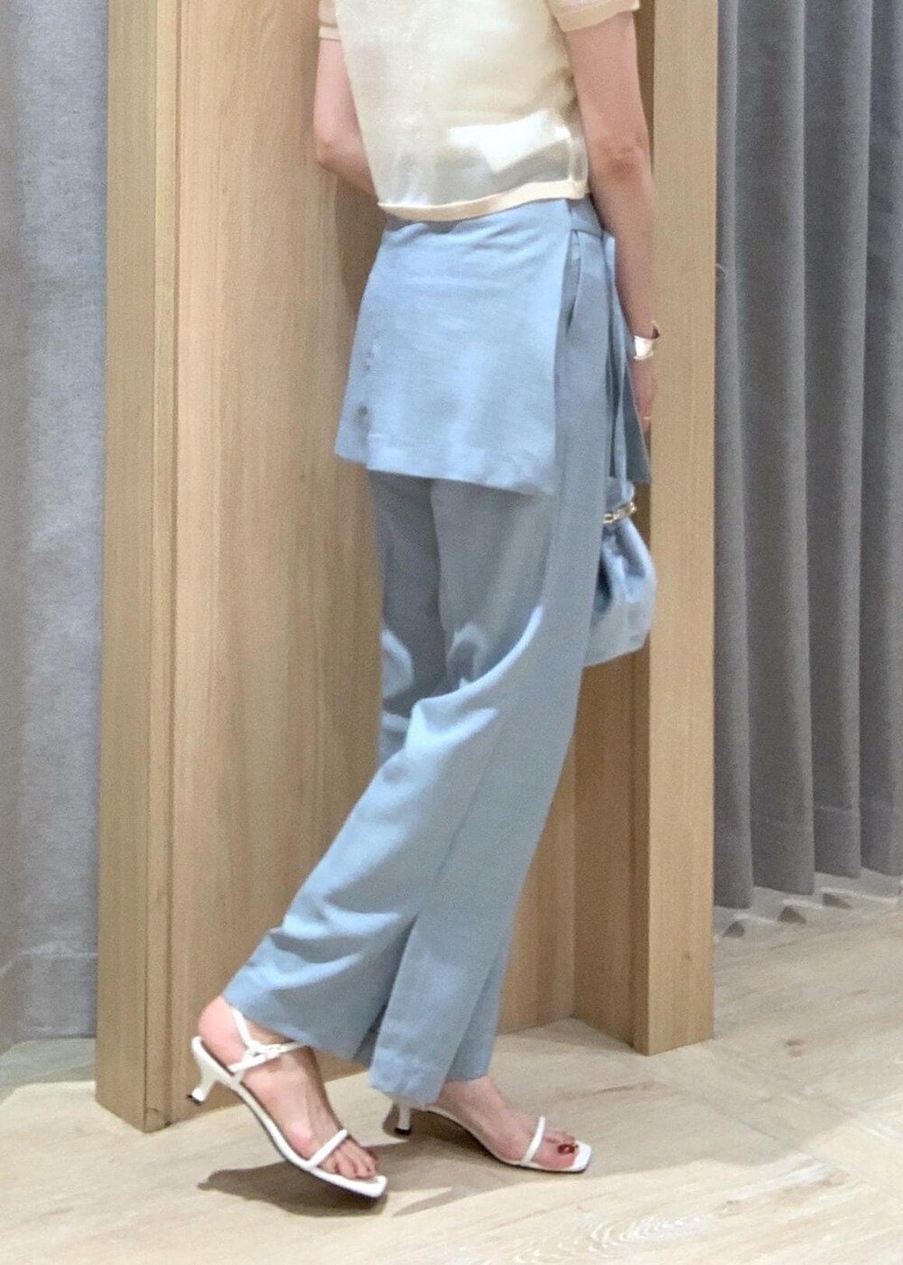 ホワイト系のサンダル、ブルー系のスラックス、ブルー系のハンドバッグを着用したレディースの夏コーディネートの9枚目の写真