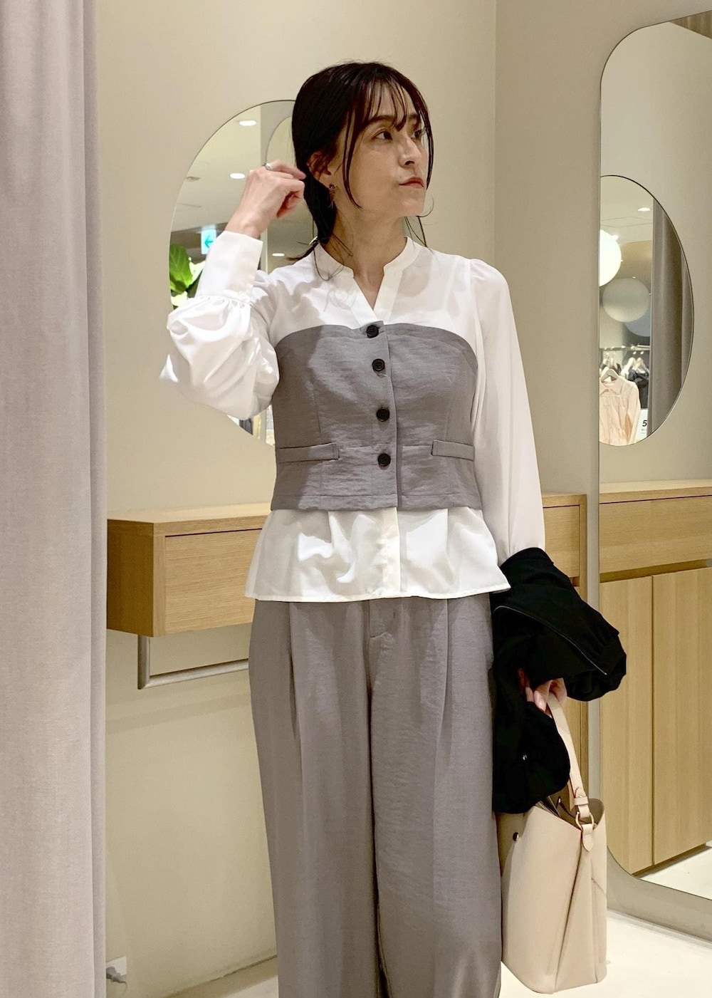 ベージュ系のショルダーバッグ、ブラック系のブルゾン、グレー系のシャツ/ブラウスを着用したレディースの春コーディネートの7枚目の写真