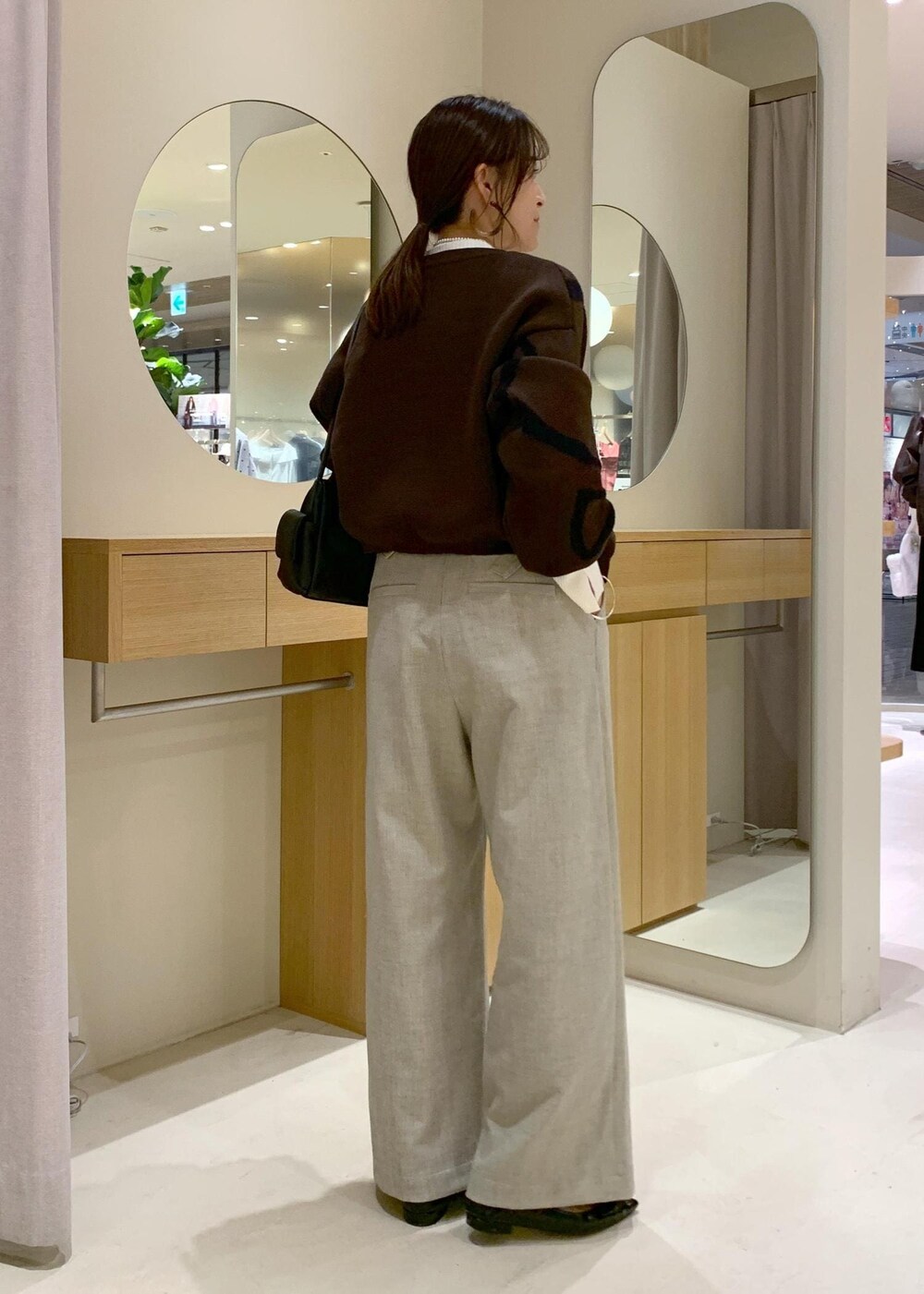 ブラック系のショルダーバッグ、ベージュ系のその他パンツ、ブラウン系のカーディガン/ボレロを着用したレディースの秋コーディネートの5枚目の写真