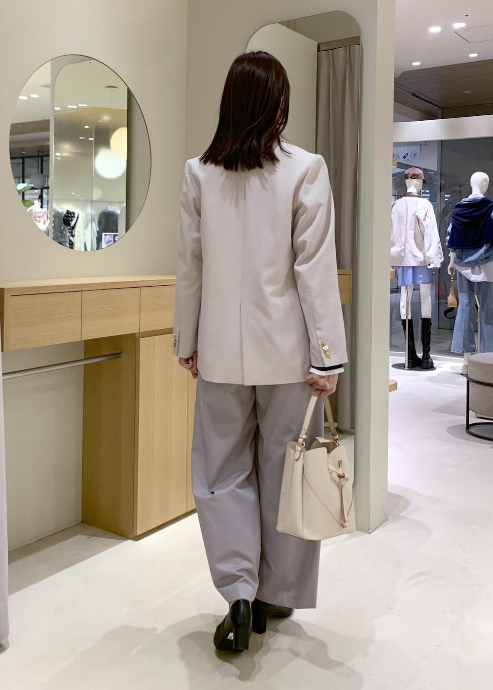 ベージュ系のショルダーバッグ、ブラック系のパンプス、ベージュ系のテーラードジャケットを着用したレディースの春コーディネートの4枚目の写真