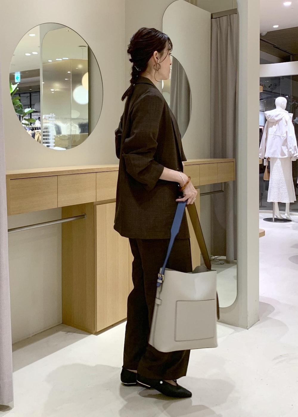ベージュ系のトートバッグ、ブラック系のパンプスを着用したレディースの春コーディネートの3枚目の写真