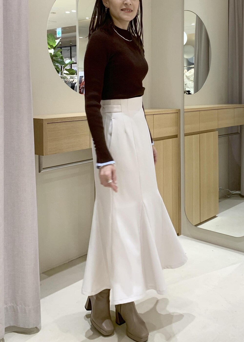 ブルー系のハンドバッグ、グレー系のその他アウター、ベージュ系のブーツを着用したレディースの冬コーディネートの7枚目の写真