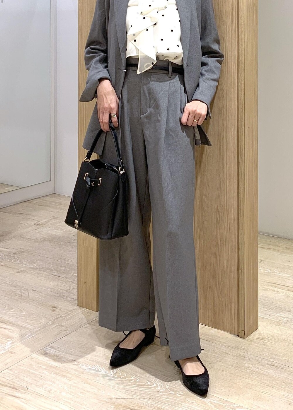 ブラック系のショルダーバッグ、グレー系のスラックス、グレー系のテーラードジャケットを着用したレディースの冬コーディネートの5枚目の写真