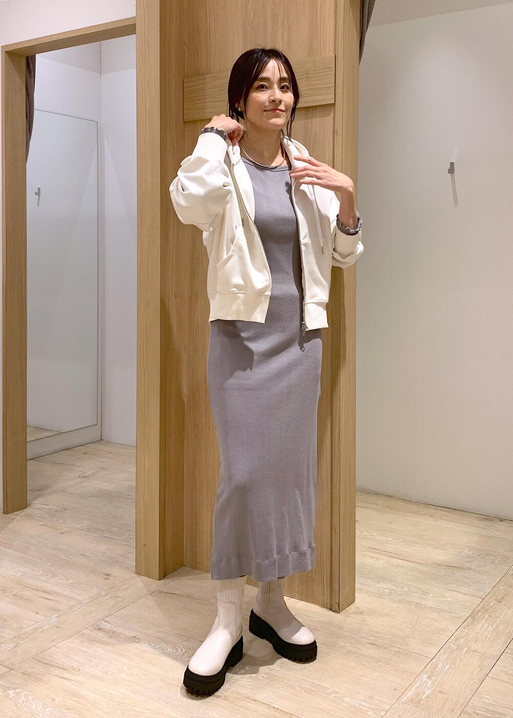 ホワイト系のブーツ、ホワイト系のパーカー、ブラック系のテーラードジャケットを着用したレディースの冬コーディネートの6枚目の写真