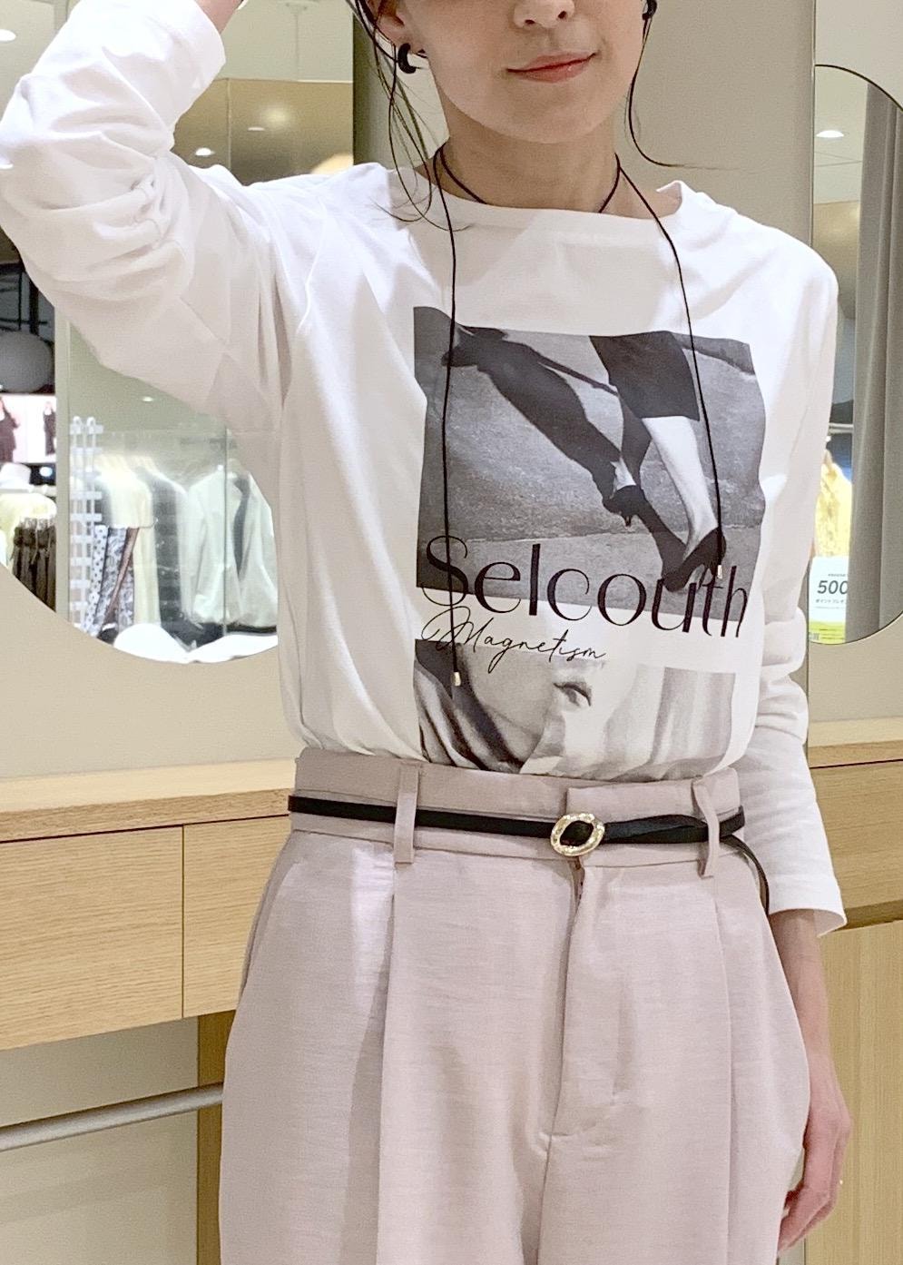 ホワイト系のショルダーバッグ、ベージュ系のパンプス、ホワイト系のナイロンジャケットを着用したレディースの春コーディネートの7枚目の写真