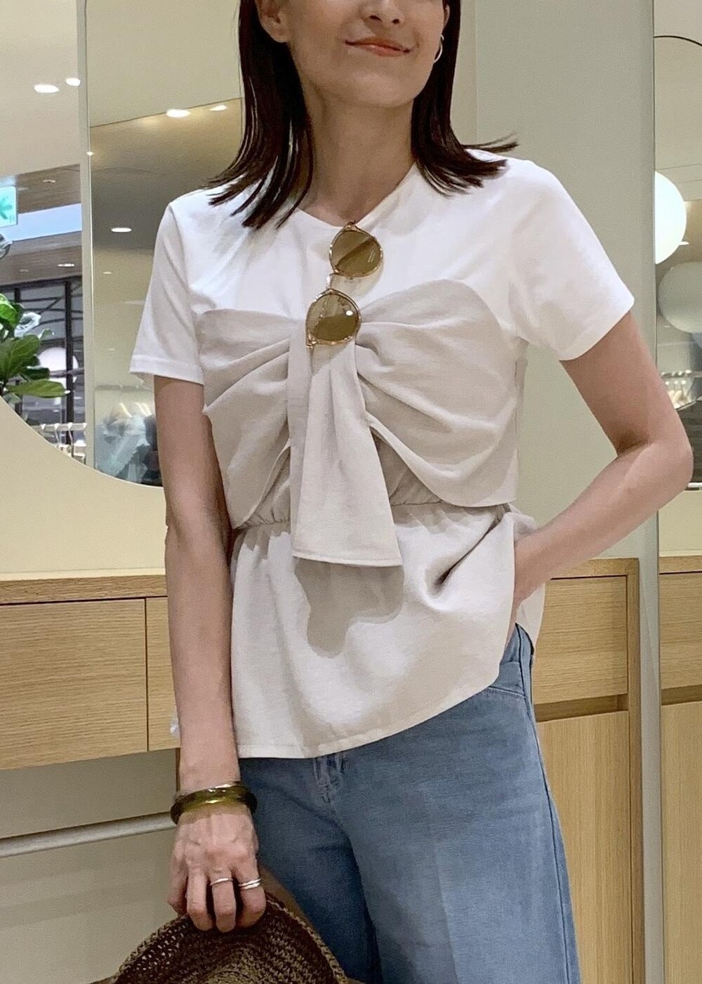 イエロー系のサンダル、ホワイト系のTシャツ/カットソー、ブルー系のデニムパンツを着用したレディースの夏コーディネートの5枚目の写真