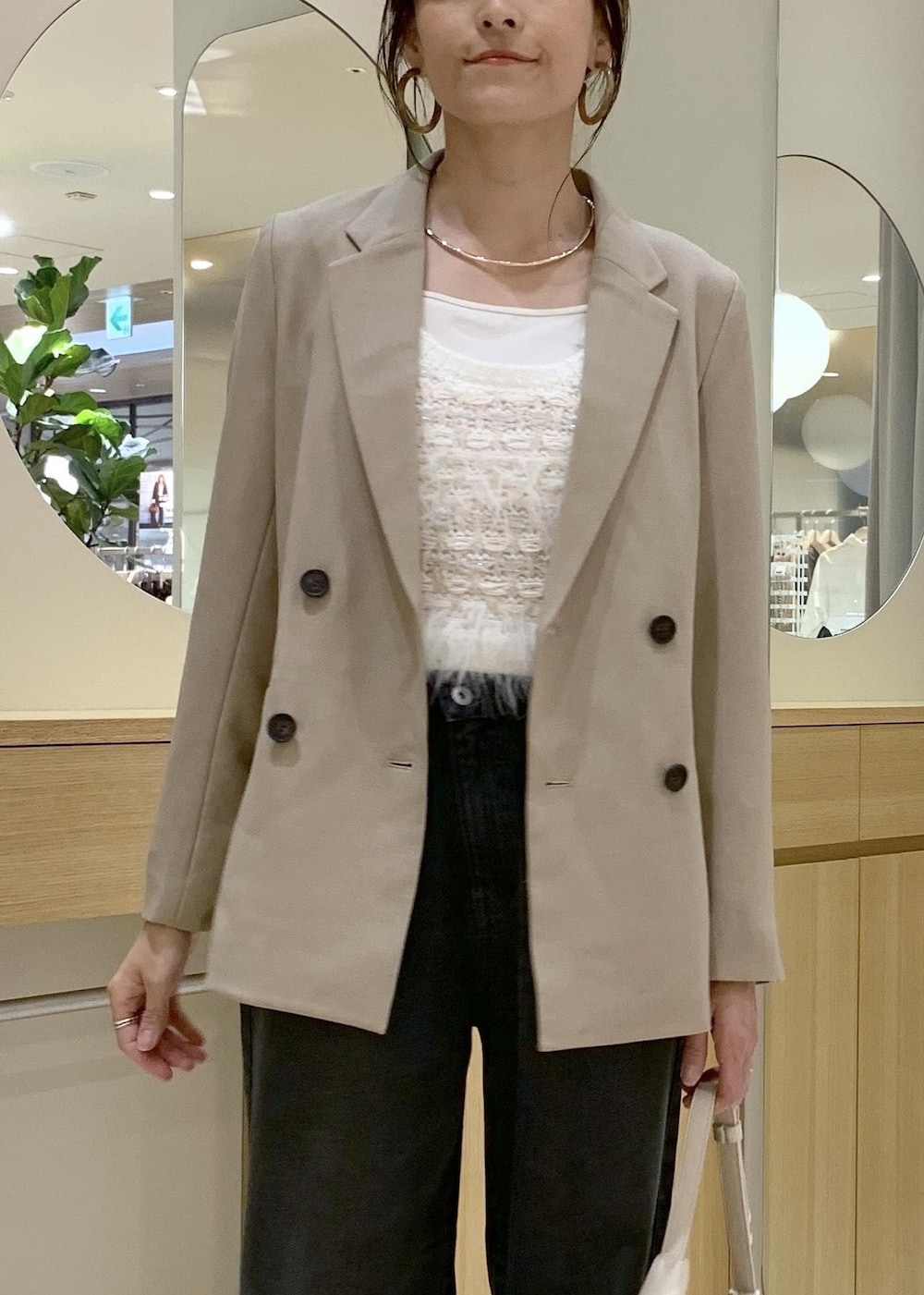 ブラウン系のブーツ、ホワイト系のベスト、グレー系のデニムパンツを着用したレディースの秋コーディネートの3枚目の写真