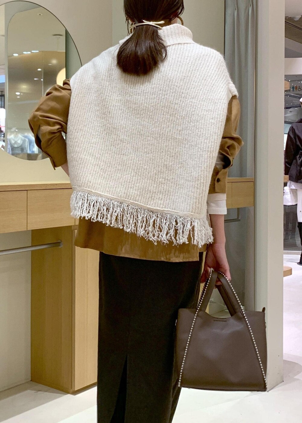 ベージュ系のブーツ、ブラウン系のスカート、イエロー系のシャツ/ブラウスを着用したレディースの秋コーディネートの7枚目の写真