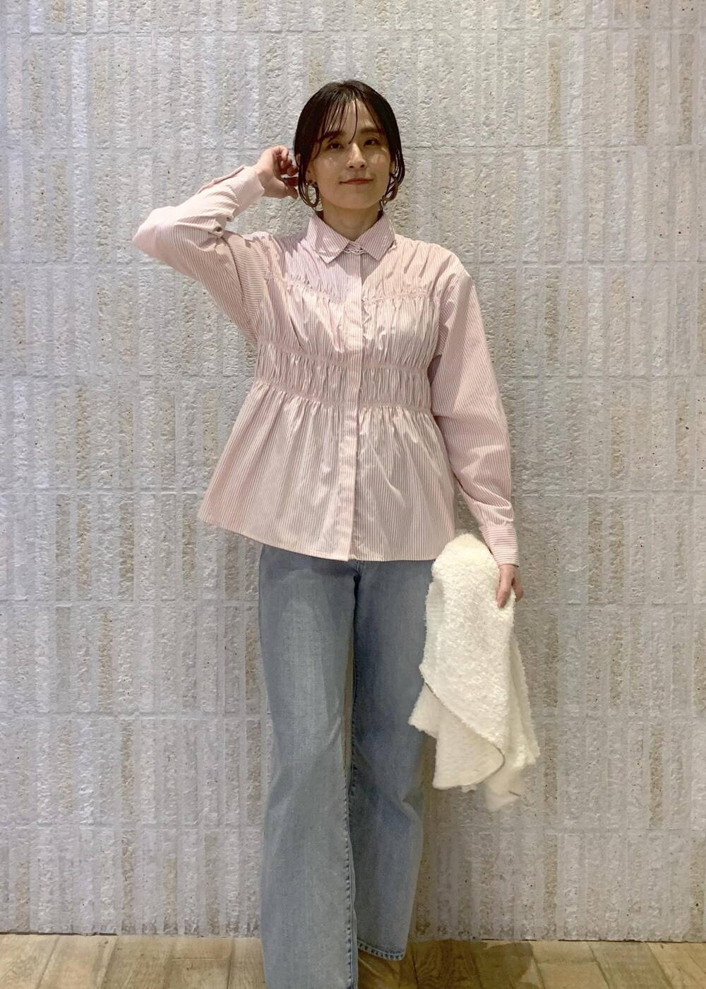 ベージュ系のブーツ、ブルー系のデニムパンツ、ピンク系のシャツ/ブラウスを着用したレディースの冬コーディネートの6枚目の写真