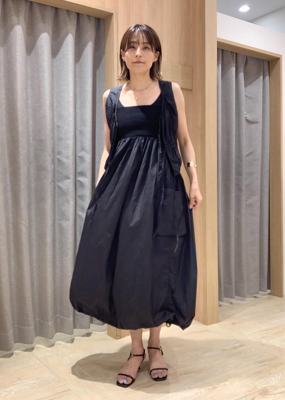 ブラック系のショルダーバッグ、ブラック系のサンダル、ブラック系のワンピースを着用したレディースの夏コーディネートの4枚目の写真