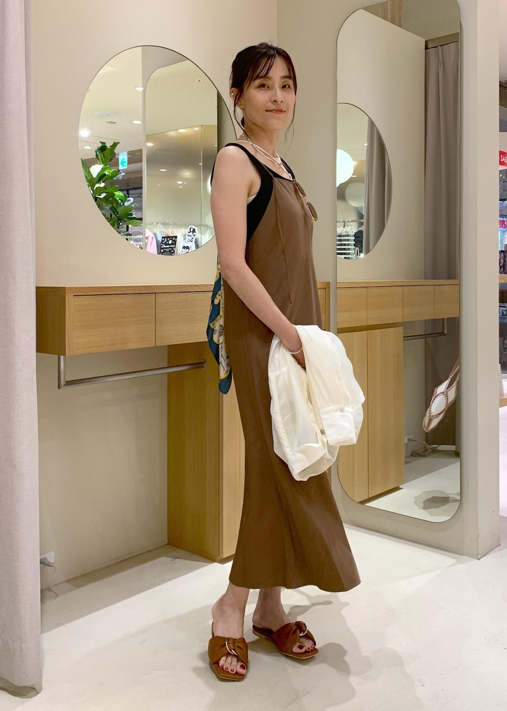 イエロー系のサンダル、ブラウン系のワンピース、ブラック系のタンクトップを着用したレディースの夏コーディネートの2枚目の写真