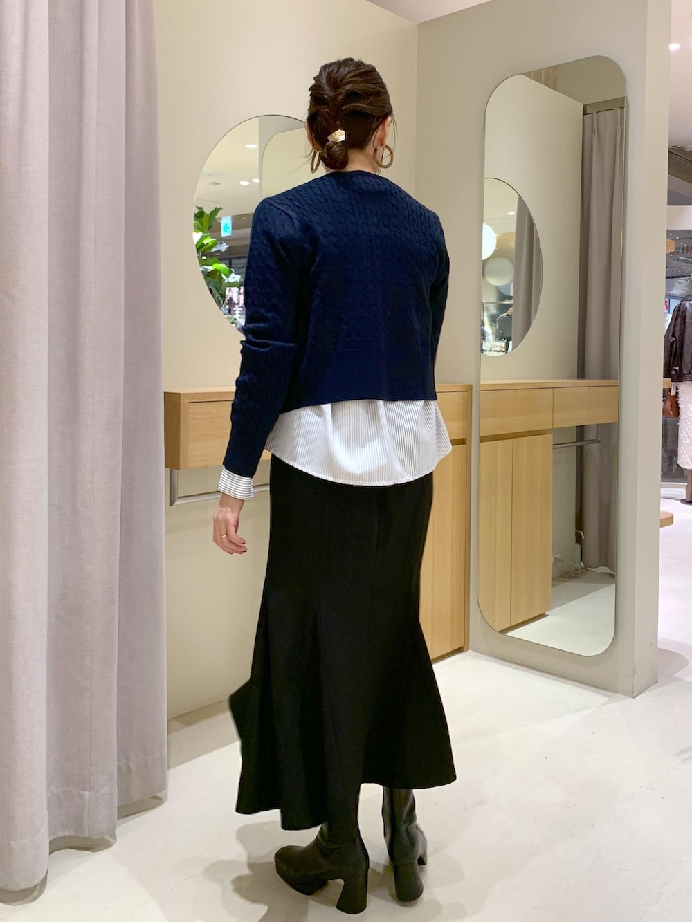 ブラック系のショルダーバッグ、ブラック系のスカート、ブルー系のカーディガン/ボレロを着用したレディースの秋コーディネートの4枚目の写真