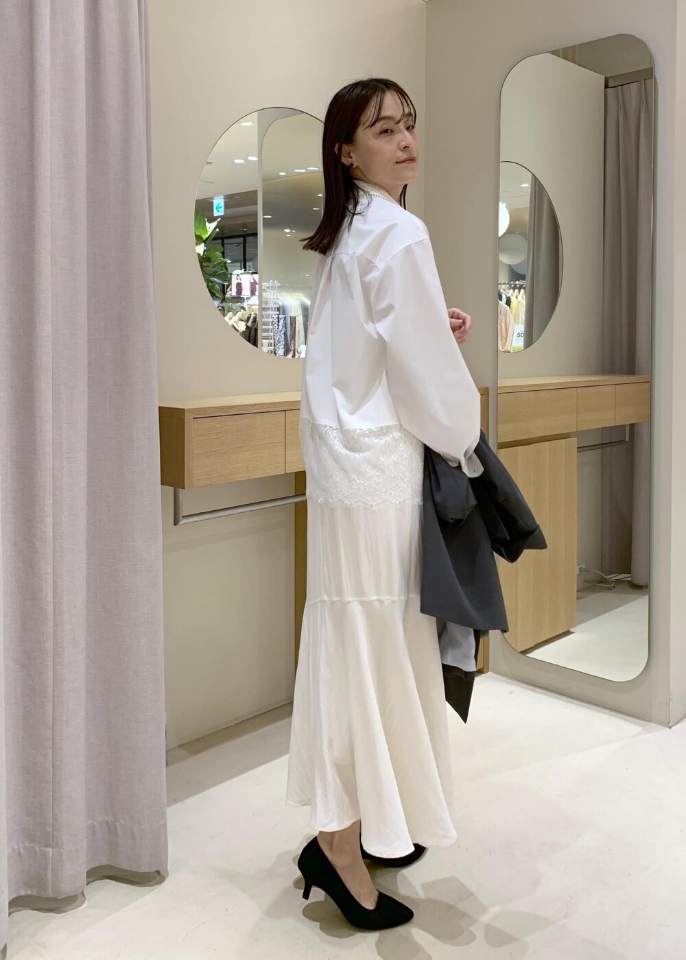 ブラック系のショルダーバッグ、ホワイト系のシャツ/ブラウス、ホワイト系のスカートを着用したレディースの春コーディネートの8枚目の写真