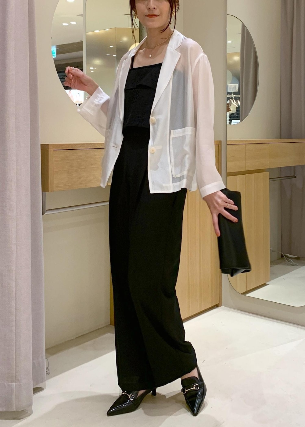 ブラック系のキャミソール、ブラック系のショルダーバッグ、ブラック系のパンプスを着用したレディースの春コーディネートの3枚目の写真