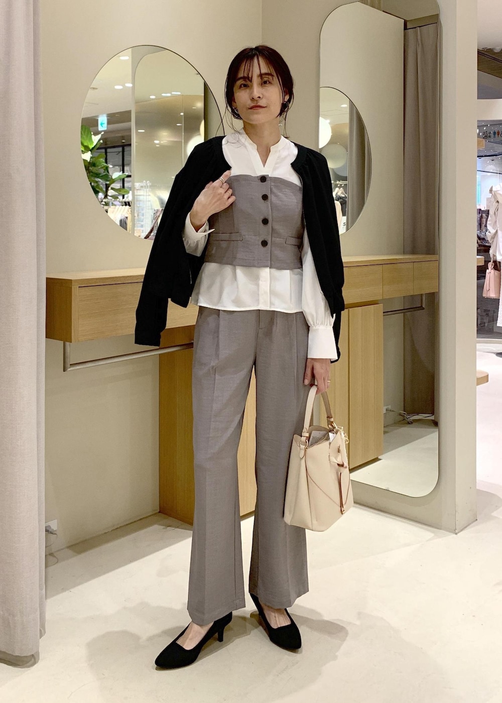 ベージュ系のショルダーバッグ、ブラック系のブルゾン、グレー系のシャツ/ブラウスを着用したレディースの春コーディネートの2枚目の写真