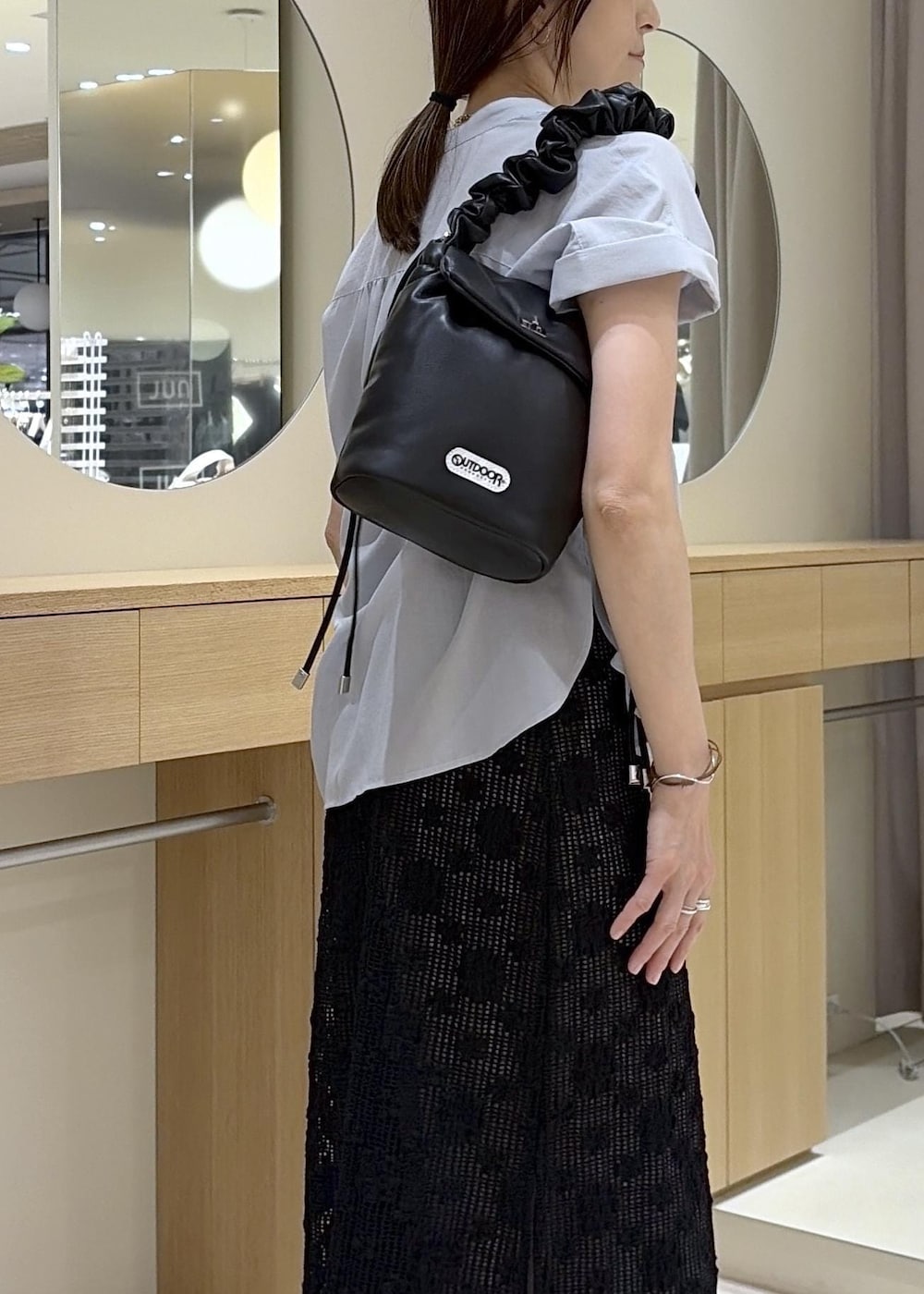 グレー系のその他パンツ、ブラック系のパンプス、ブラック系のショルダーバッグを着用したレディースの春コーディネートの9枚目の写真