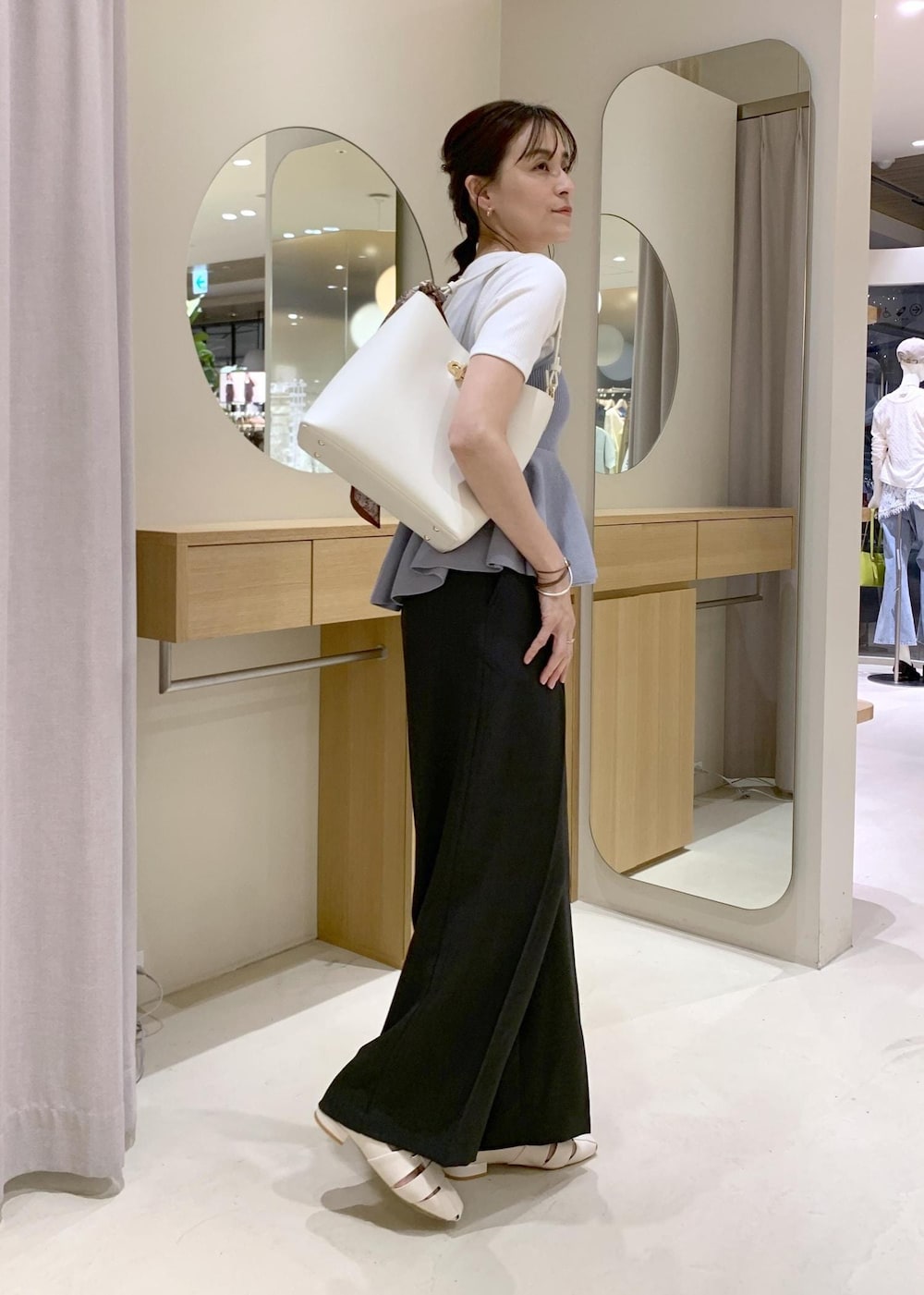 ホワイト系のショルダーバッグ、グレー系のその他パンツ、ホワイト系のパンプスを着用したレディースの春コーディネートの4枚目の写真