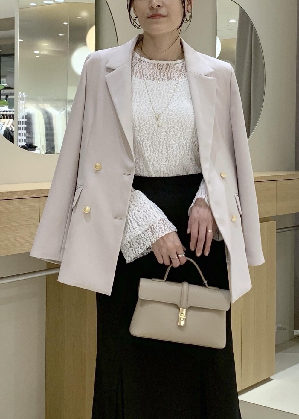ブラック系のスカート、ホワイト系のTシャツ/カットソー、ベージュ系のテーラードジャケットを着用したレディースの冬コーディネートの6枚目の写真