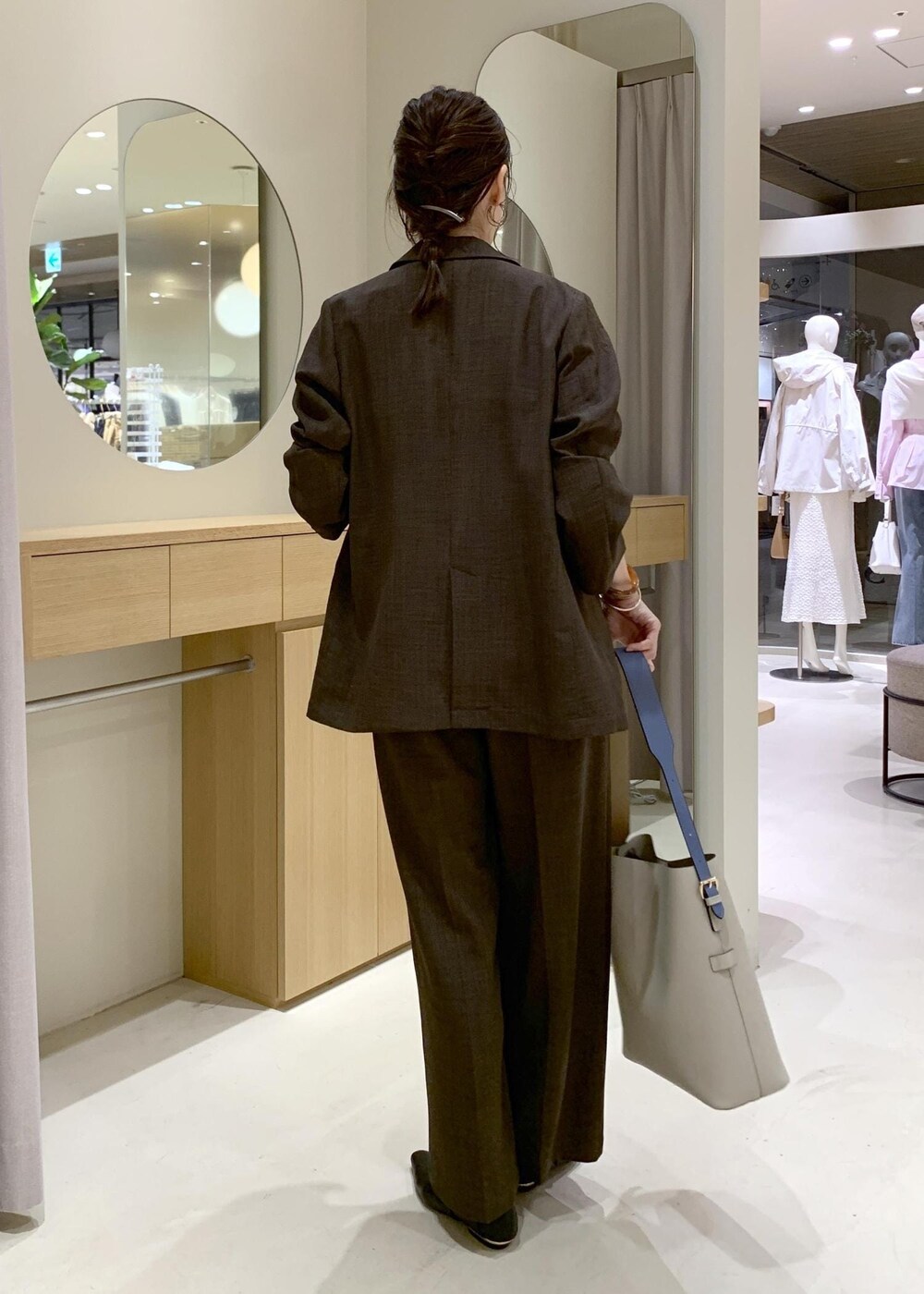 ベージュ系のトートバッグ、ブラック系のパンプスを着用したレディースの春コーディネートの5枚目の写真