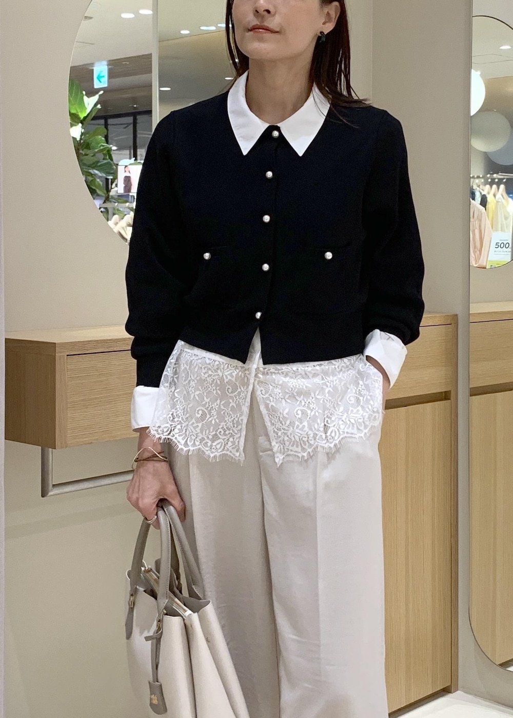 ベージュ系のパンプス、ホワイト系のシャツ/ブラウス、ブラック系のカーディガン/ボレロを着用したレディースの春コーディネートの4枚目の写真