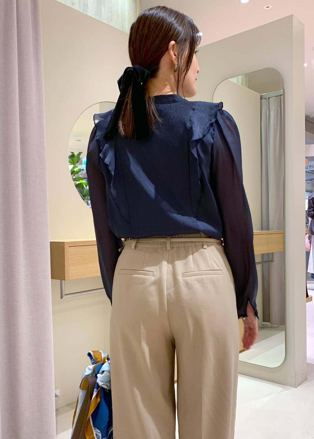 ブラウン系のハンドバッグ、ホワイト系のパンプス、ブルー系のシャツ/ブラウスを着用したレディースの秋コーディネートの6枚目の写真