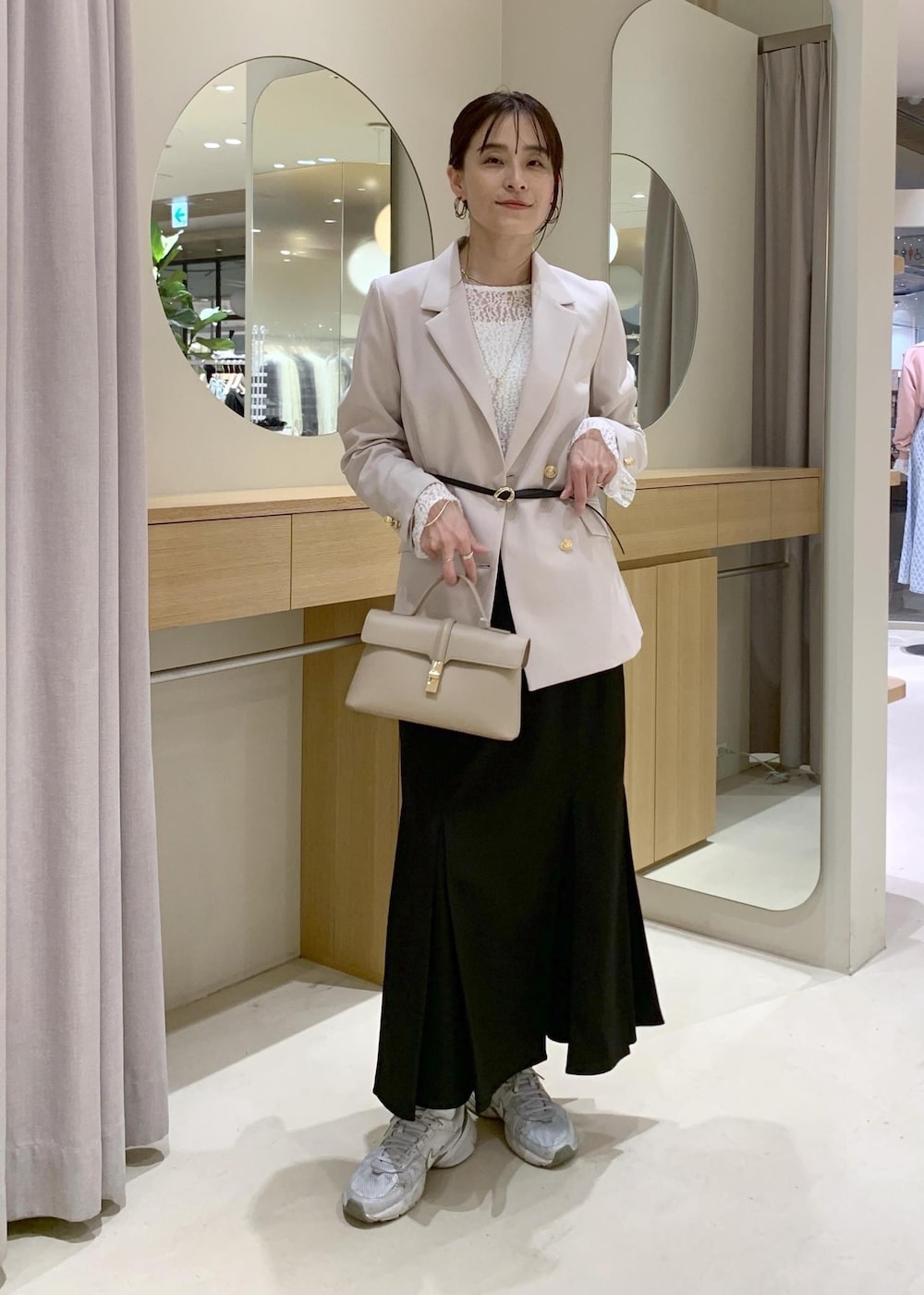 ブラック系のスカート、ホワイト系のTシャツ/カットソー、ベージュ系のテーラードジャケットを着用したレディースの冬コーディネートの3枚目の写真