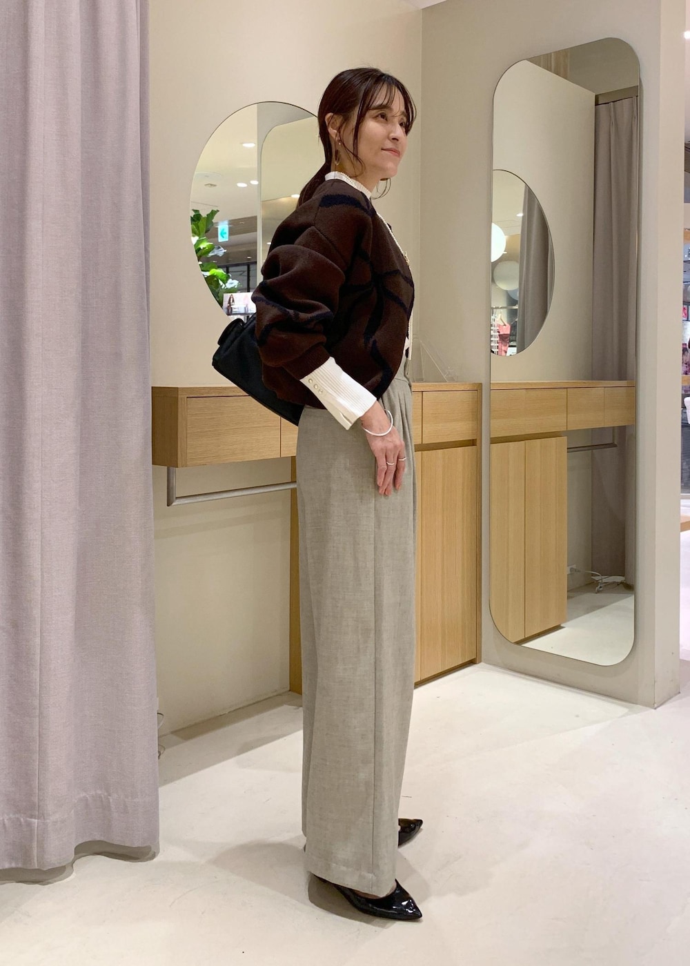 ブラック系のショルダーバッグ、ベージュ系のその他パンツ、ブラウン系のカーディガン/ボレロを着用したレディースの秋コーディネートの4枚目の写真