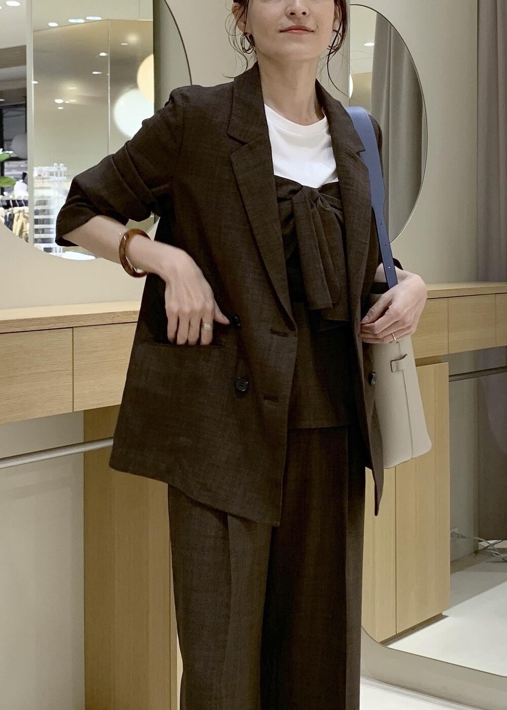 ベージュ系のトートバッグ、ブラック系のパンプスを着用したレディースの春コーディネートの6枚目の写真