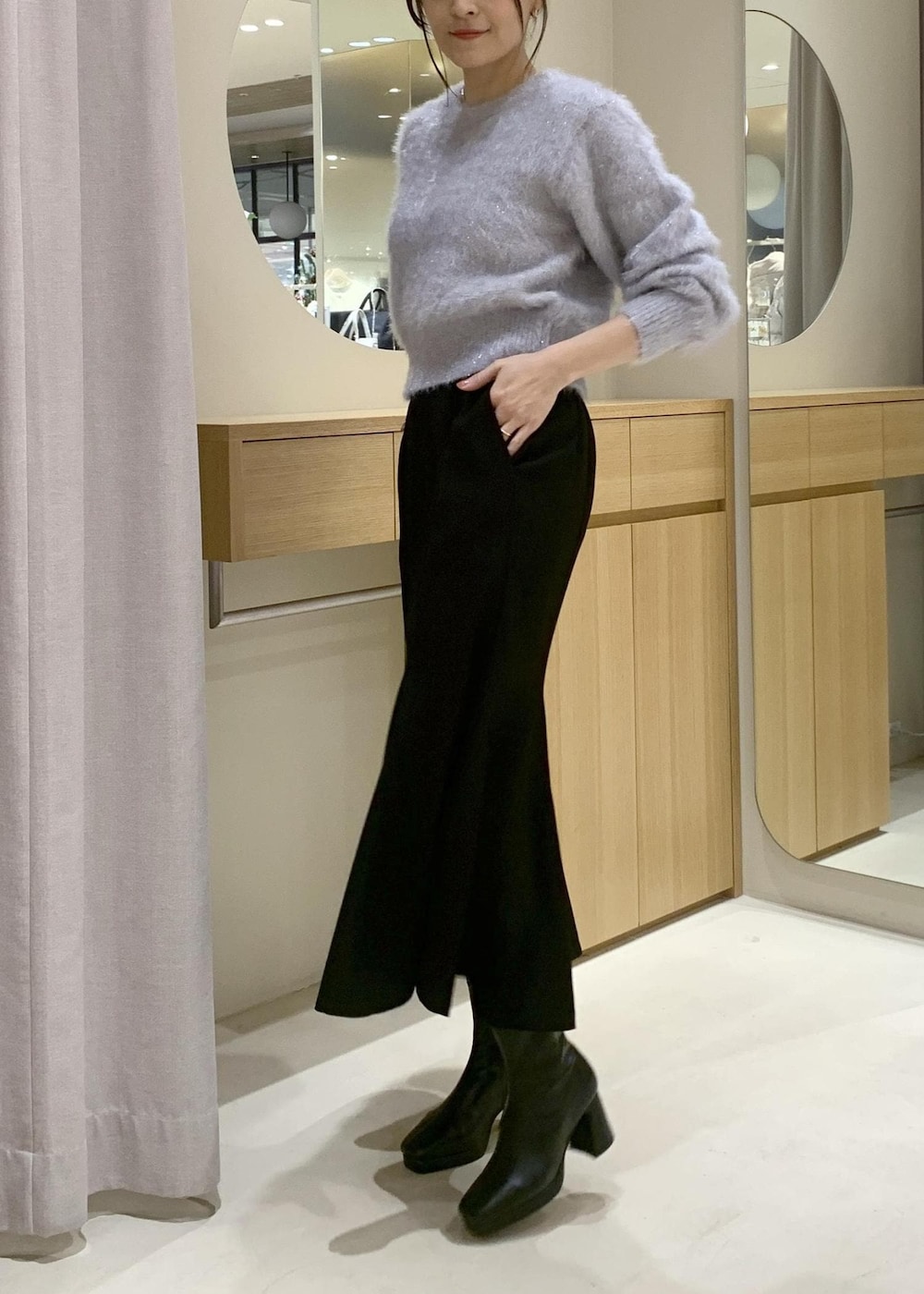 ブラック系のショルダーバッグ、ブラック系のブーツ、ブラック系のスカートを着用したレディースの秋コーディネートの7枚目の写真