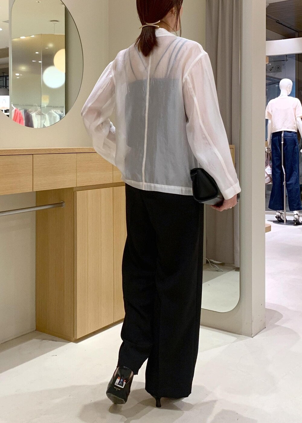 ブラック系のキャミソール、ブラック系のショルダーバッグ、ブラック系のパンプスを着用したレディースの春コーディネートの6枚目の写真