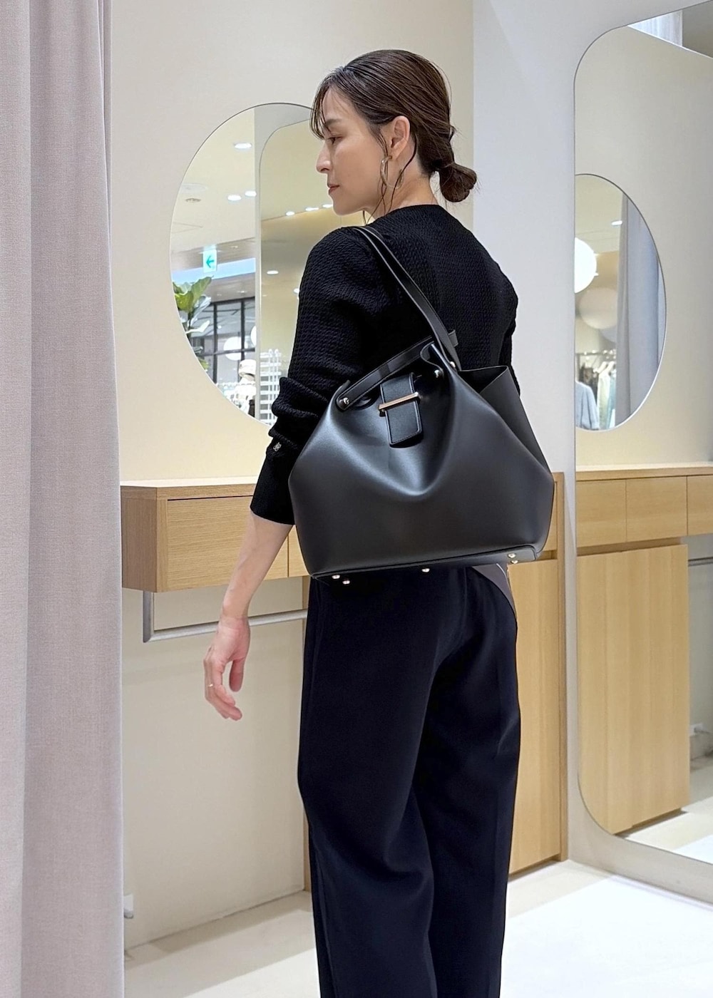 ブラック系のキャミソール、ブルー系のその他パンツ、ブラック系のビジネスバッグを着用したレディースの秋コーディネートの9枚目の写真