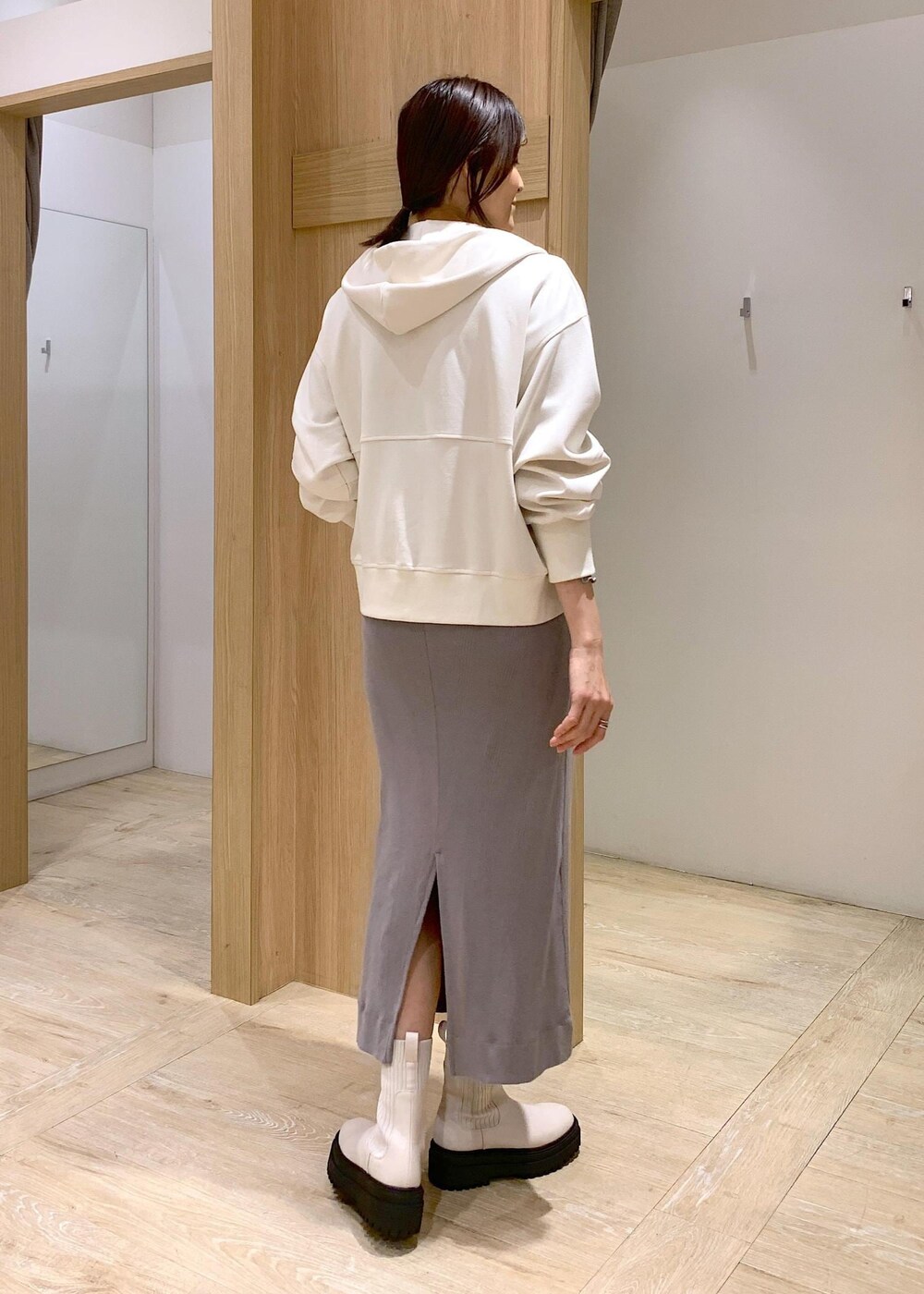 ホワイト系のブーツ、ホワイト系のパーカー、ブラック系のテーラードジャケットを着用したレディースの冬コーディネートの8枚目の写真