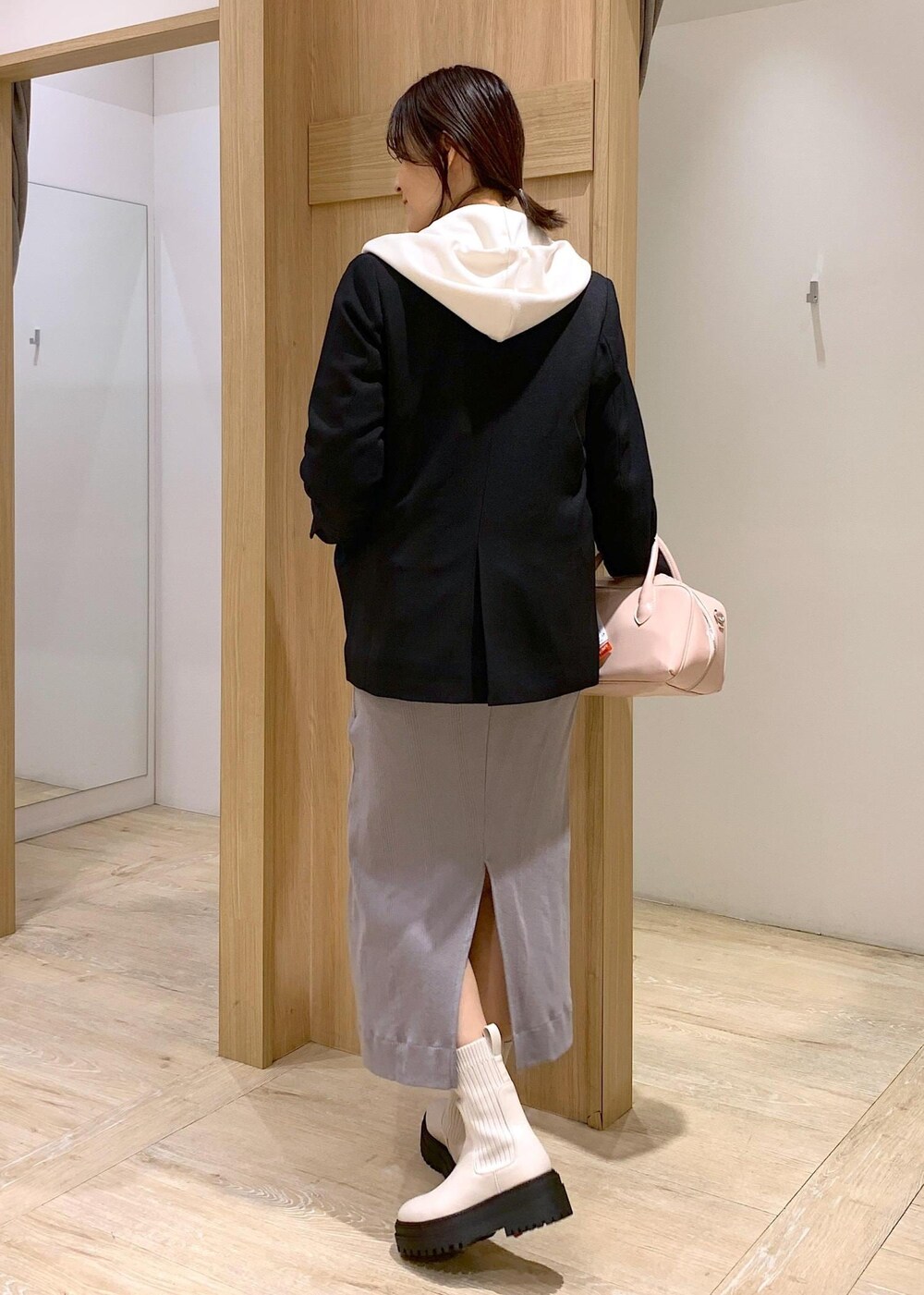 ホワイト系のブーツ、ホワイト系のパーカー、ブラック系のテーラードジャケットを着用したレディースの冬コーディネートの4枚目の写真
