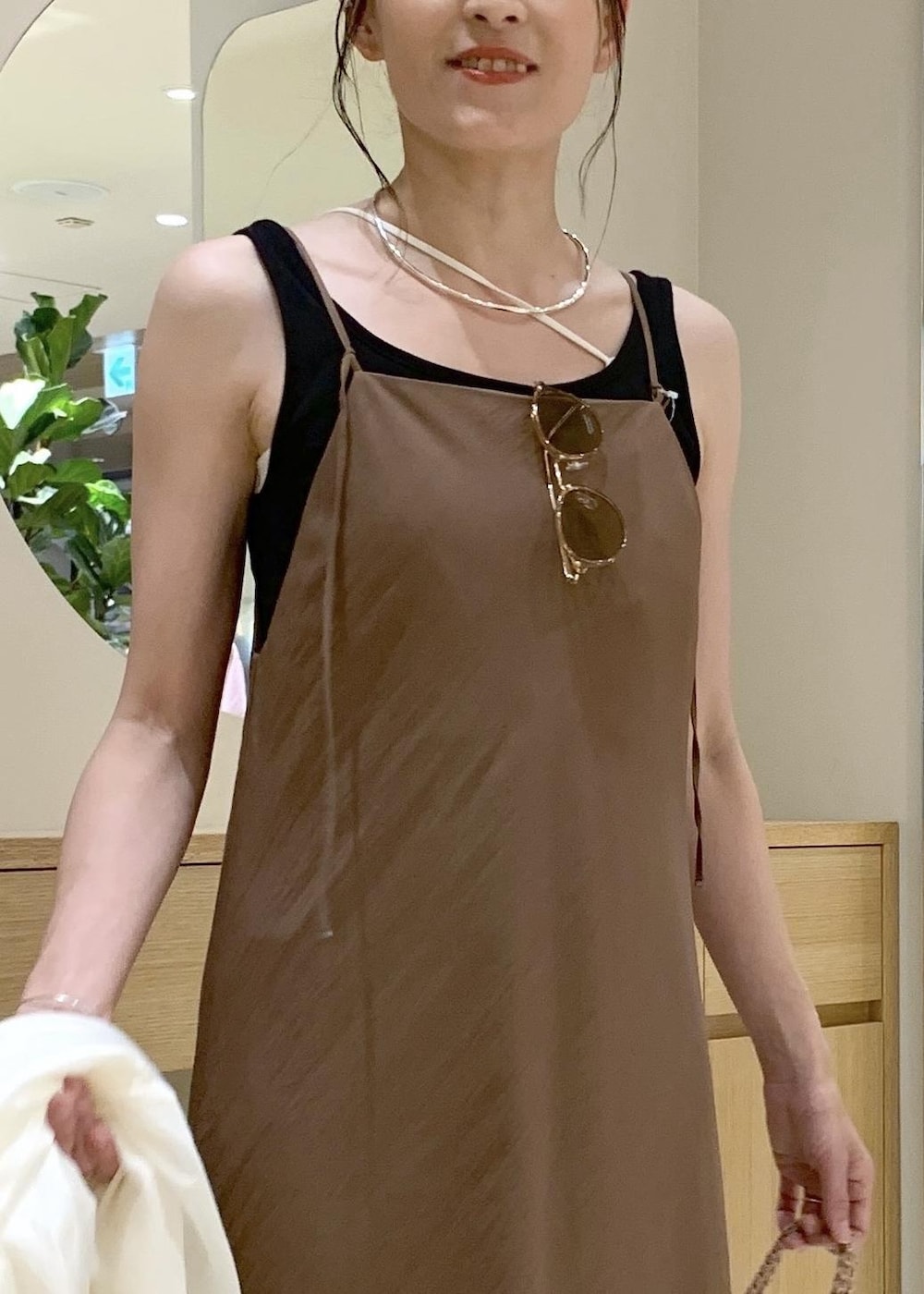 イエロー系のサンダル、ブラウン系のワンピース、ブラック系のタンクトップを着用したレディースの夏コーディネートの6枚目の写真