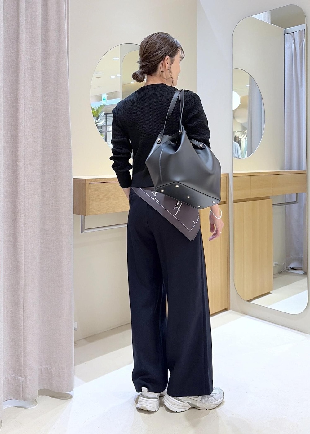 ブラック系のキャミソール、ブルー系のその他パンツ、ブラック系のビジネスバッグを着用したレディースの秋コーディネートの3枚目の写真