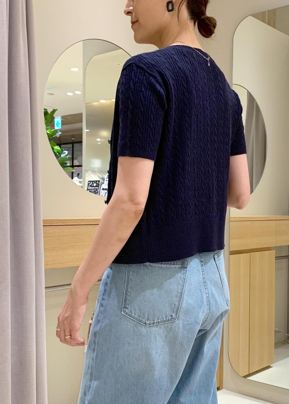 ブラック系のキャミソール、ブルー系のデニムパンツ、ホワイト系のサンダルを着用したレディースの夏コーディネートの6枚目の写真