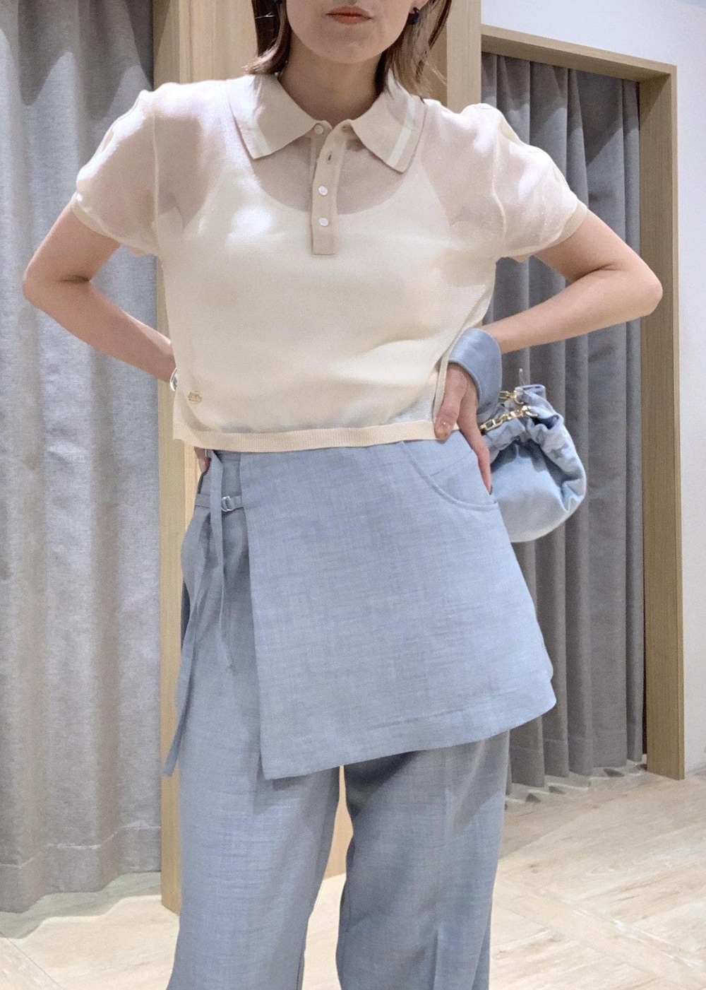 ホワイト系のサンダル、ブルー系のスラックス、ブルー系のハンドバッグを着用したレディースの夏コーディネートの4枚目の写真