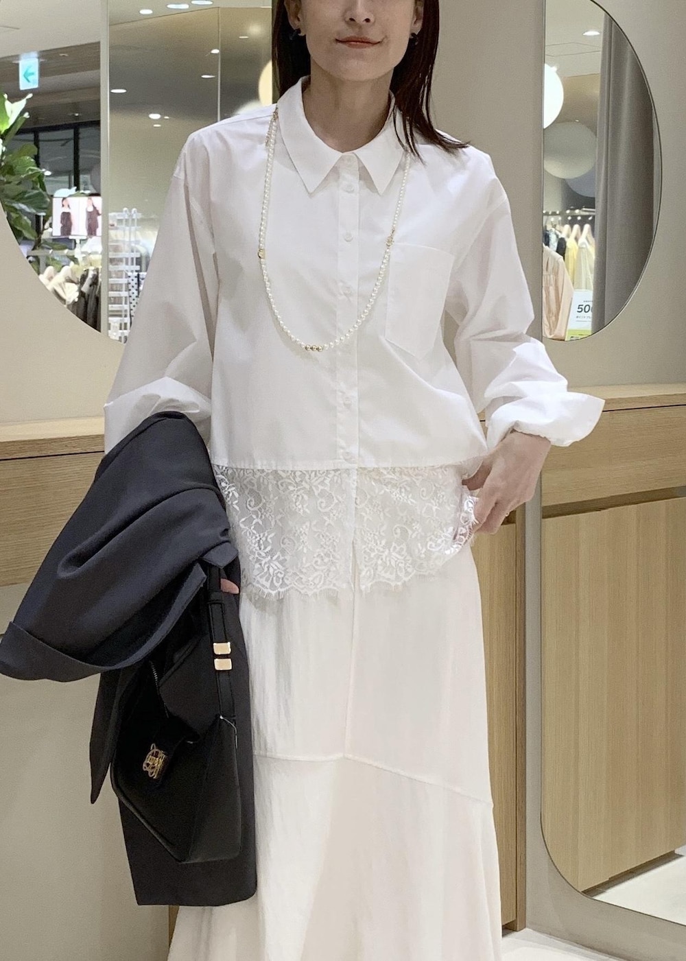 ブラック系のショルダーバッグ、ホワイト系のシャツ/ブラウス、ホワイト系のスカートを着用したレディースの春コーディネートの10枚目の写真