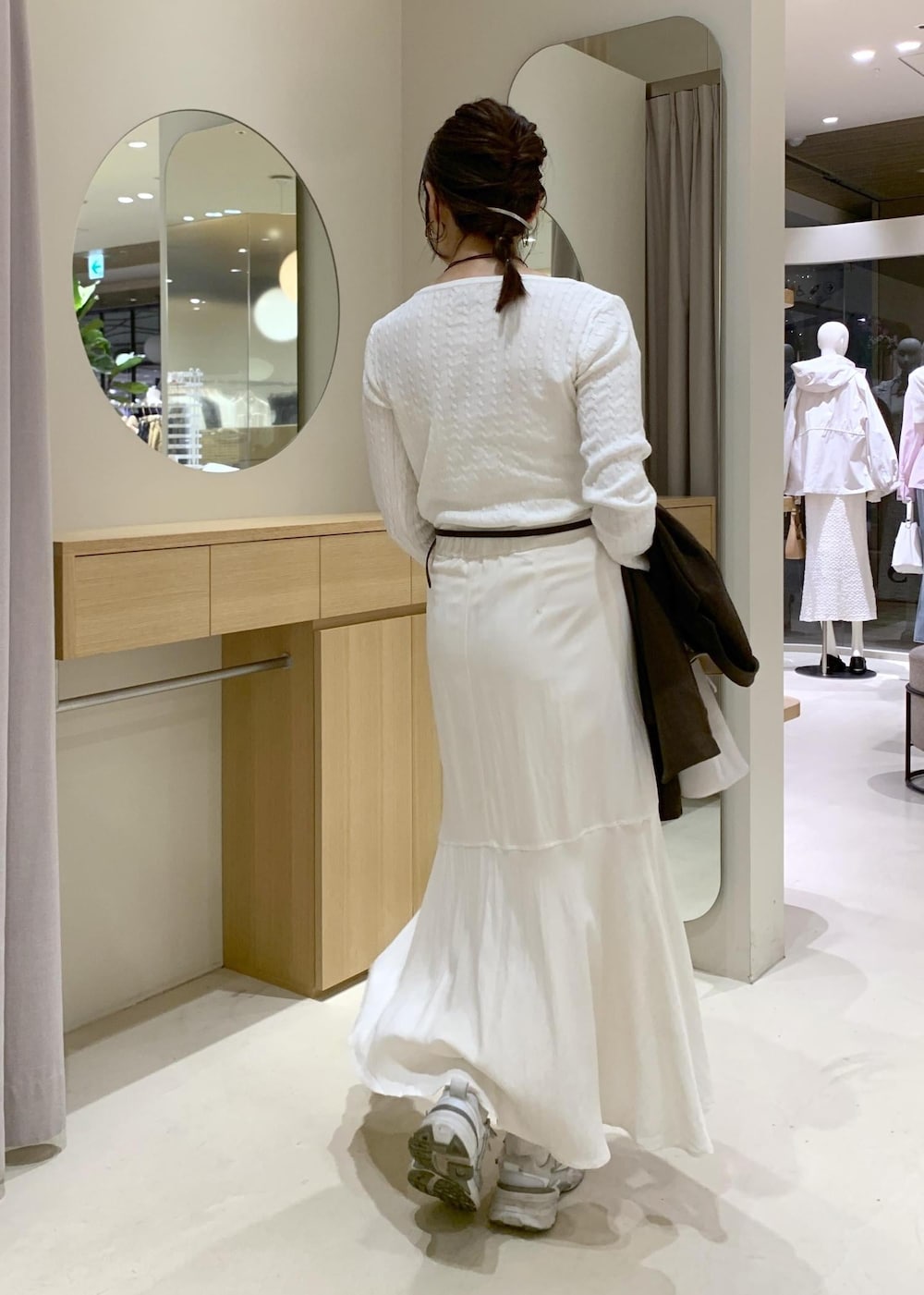 ホワイト系のハンドバッグ、ホワイト系のスカート、ホワイト系のニット/セーターを着用したレディースの春コーディネートの6枚目の写真