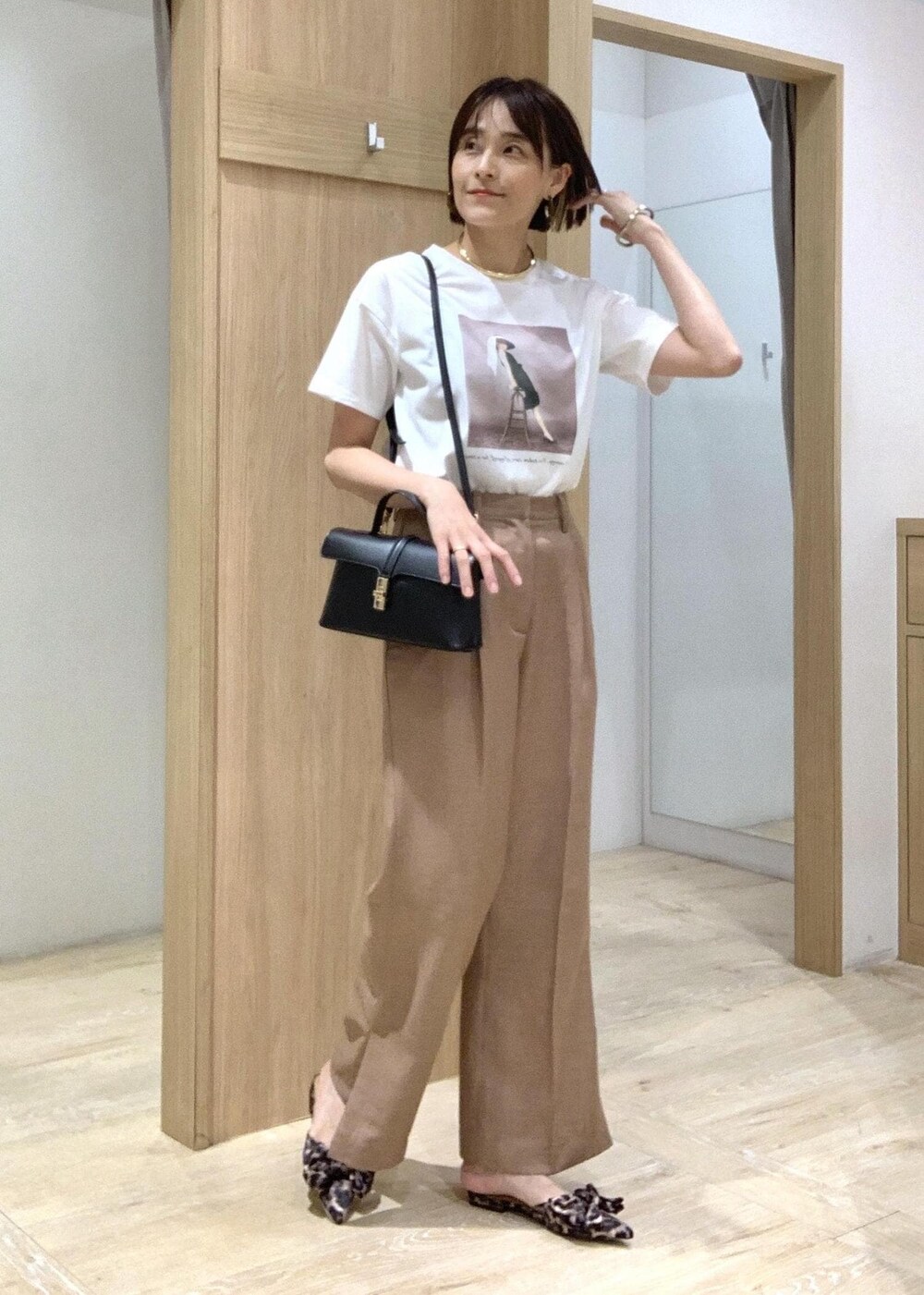 ホワイト系のTシャツ/カットソー、その他のサンダル、ブラウン系のスラックスを着用したレディースの夏コーディネートの3枚目の写真