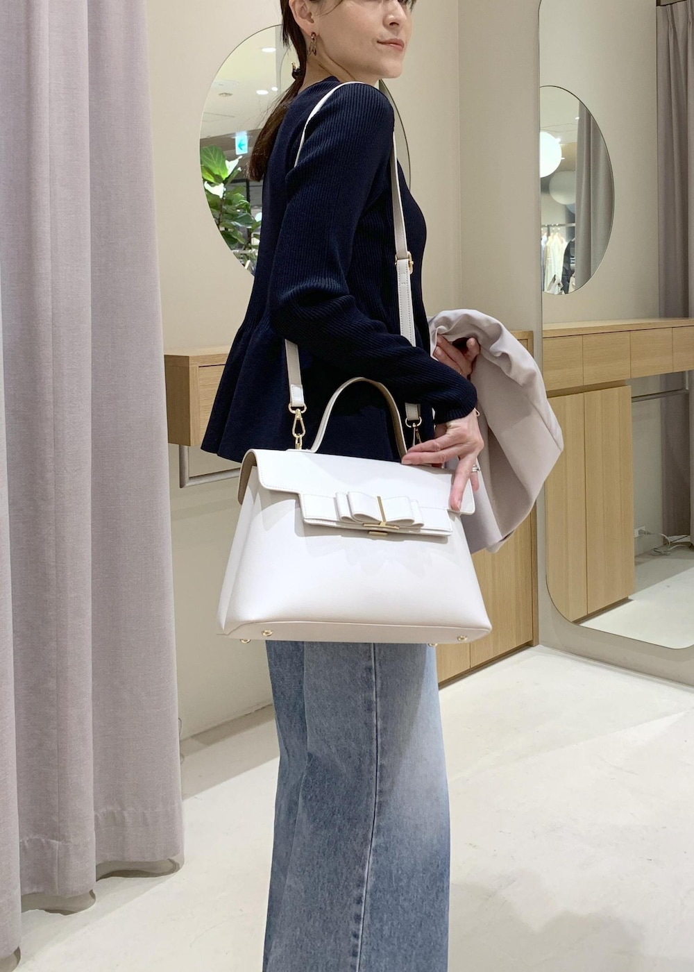 ブルー系のカーディガン/ボレロ、ブルー系のデニムパンツ、ベージュ系のテーラードジャケットを着用したレディースの冬コーディネートの3枚目の写真