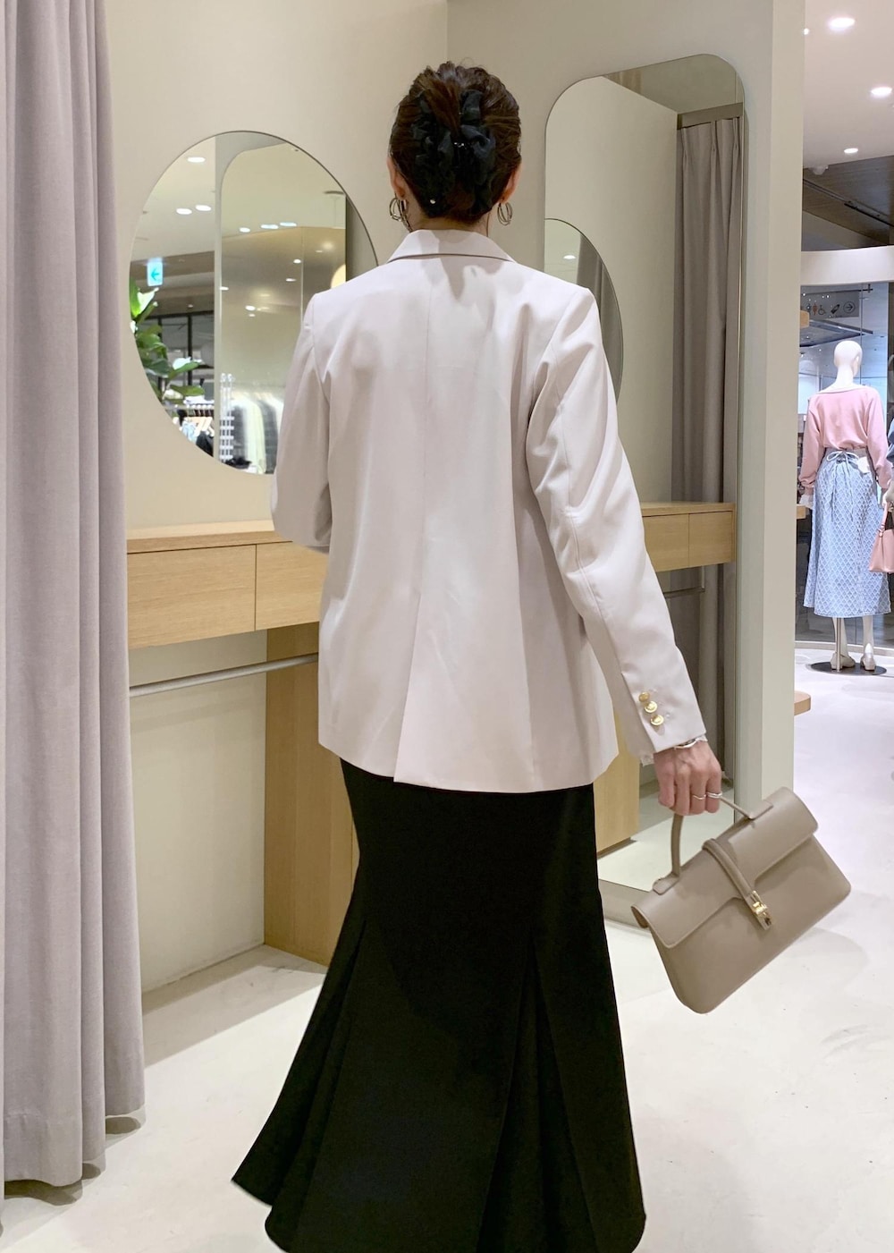 ブラック系のスカート、ホワイト系のTシャツ/カットソー、ベージュ系のテーラードジャケットを着用したレディースの冬コーディネートの4枚目の写真