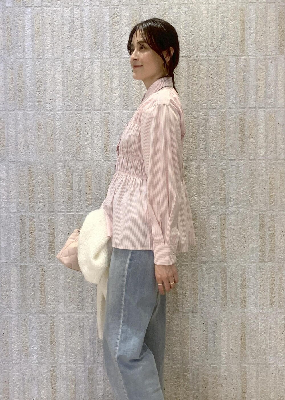 ベージュ系のブーツ、ブルー系のデニムパンツ、ピンク系のシャツ/ブラウスを着用したレディースの冬コーディネートの7枚目の写真