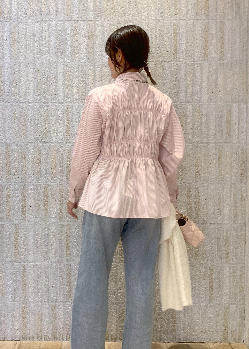 ベージュ系のブーツ、ブルー系のデニムパンツ、ピンク系のシャツ/ブラウスを着用したレディースの冬コーディネートの9枚目の写真