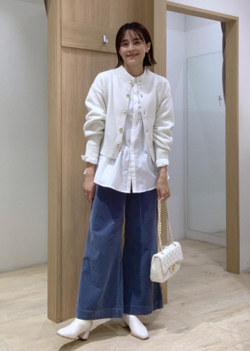 ホワイト系のショルダーバッグ、ホワイト系のカーディガン/ボレロ、ホワイト系のブーツを着用したレディースの秋コーディネートの3枚目の写真