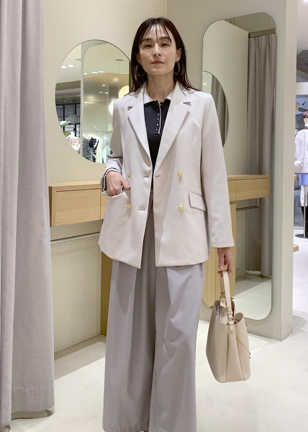 ベージュ系のショルダーバッグ、ブラック系のパンプス、ベージュ系のテーラードジャケットを着用したレディースの春コーディネートの3枚目の写真