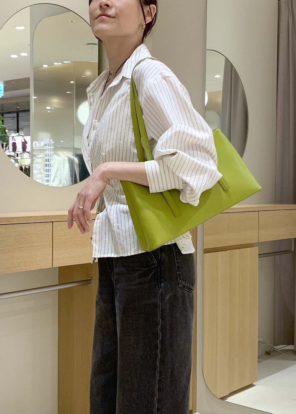 ホワイト系のキャミソール、ベージュ系のパンプス、ブラック系のデニムパンツを着用したレディースの春コーディネートの7枚目の写真